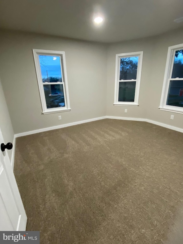 empty room featuring dark carpet