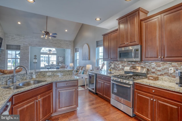 kitchen with vaulted ceiling, a healthy amount of sunlight, appliances with stainless steel finishes, and sink