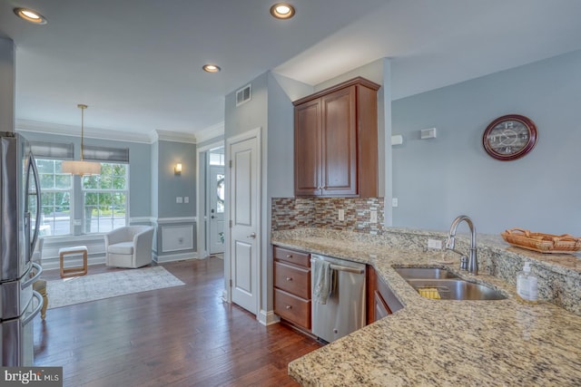 kitchen featuring light stone countertops, sink, dark hardwood / wood-style flooring, stainless steel appliances, and decorative light fixtures