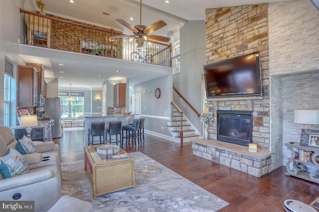 living room with a fireplace, dark hardwood / wood-style floors, high vaulted ceiling, and ceiling fan