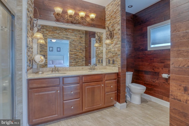 bathroom featuring toilet, vanity, and wooden walls