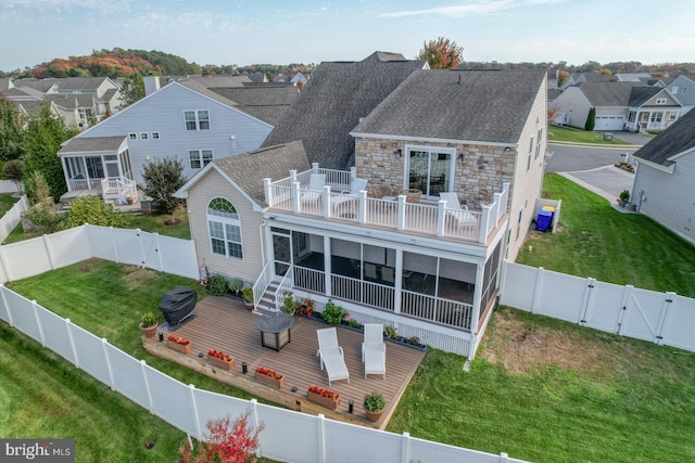 rear view of house with a sunroom and a lawn