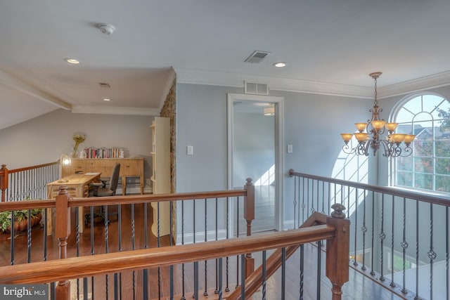 hall with ornamental molding, wood-type flooring, and an inviting chandelier