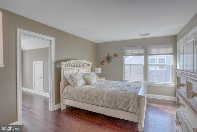 bedroom with dark hardwood / wood-style floors