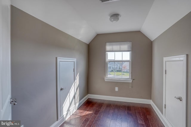 additional living space with vaulted ceiling and dark hardwood / wood-style floors