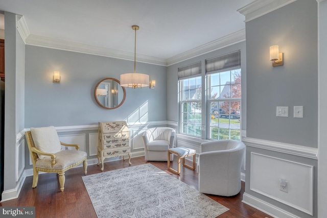 sitting room featuring ornamental molding, an inviting chandelier, and dark hardwood / wood-style flooring