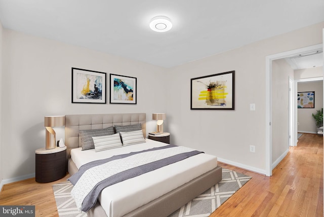 bedroom with light wood finished floors and baseboards