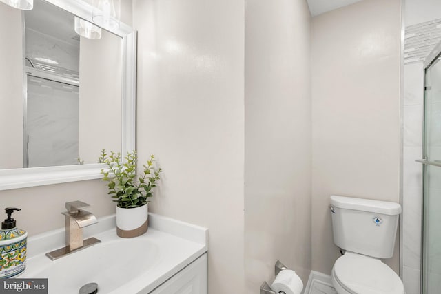 bathroom featuring toilet, an enclosed shower, and vanity