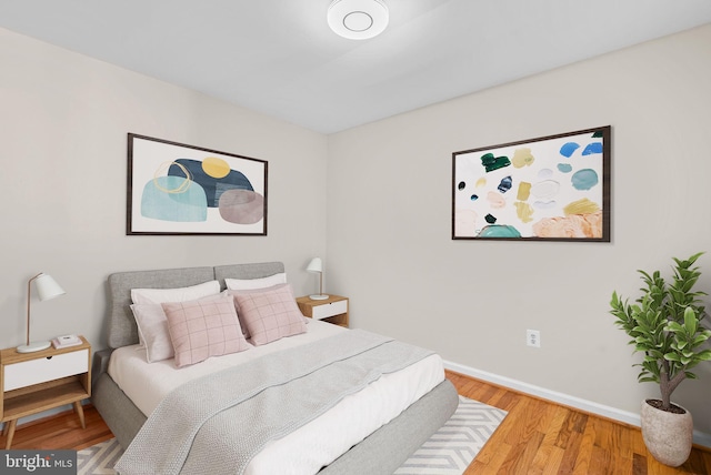 bedroom with baseboards and wood finished floors