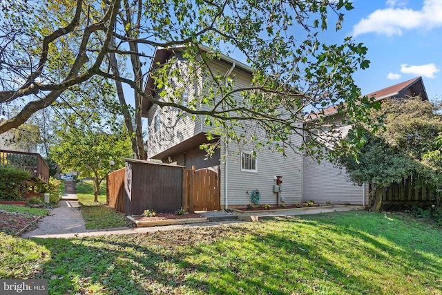 rear view of house featuring fence and a yard