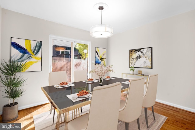 dining area featuring baseboards and wood finished floors