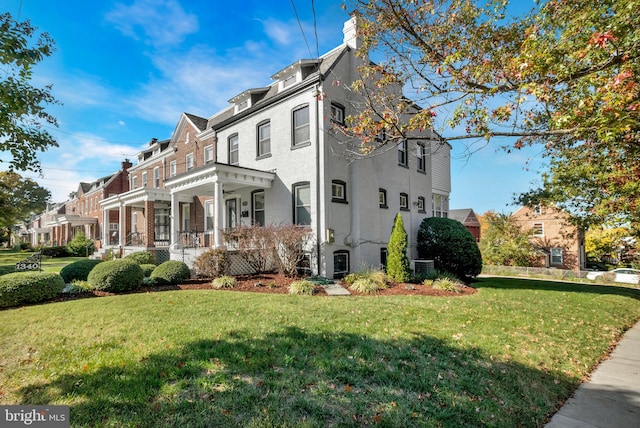 view of front of house with a front yard, covered porch, and central air condition unit