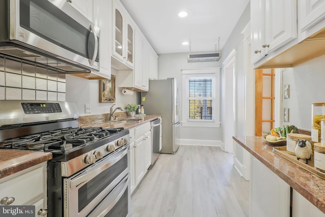 kitchen featuring sink, white cabinetry, stainless steel appliances, and light wood-type flooring