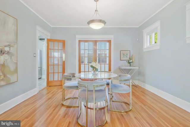 dining area featuring crown molding and light hardwood / wood-style flooring