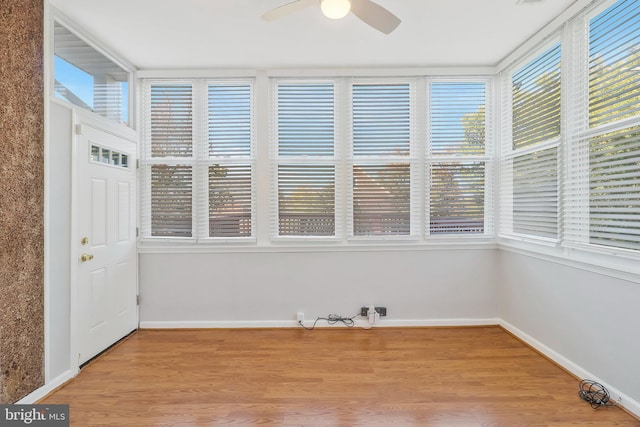 unfurnished sunroom featuring ceiling fan