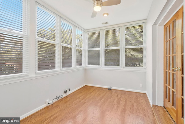 unfurnished sunroom featuring ceiling fan