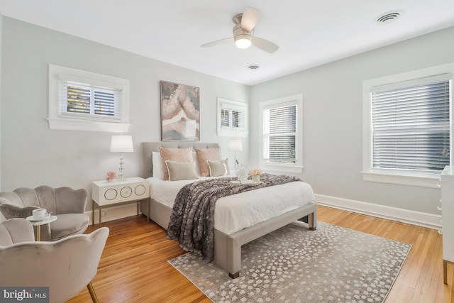 bedroom with multiple windows, light wood-type flooring, and ceiling fan