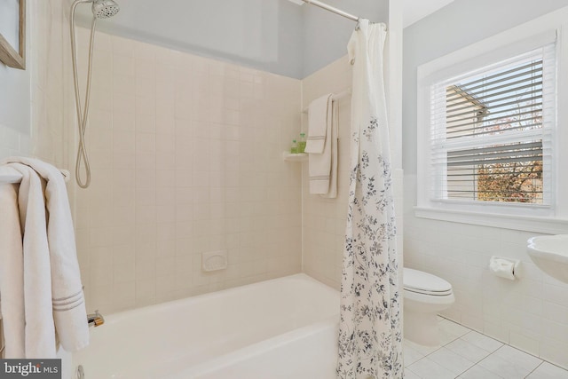 bathroom with toilet, shower / bathtub combination with curtain, tile patterned floors, and tile walls