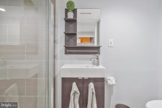 bathroom featuring vanity, toilet, and an enclosed shower