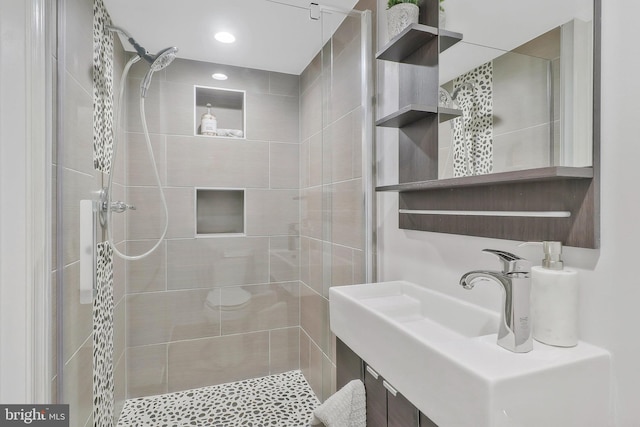 bathroom featuring vanity and tiled shower