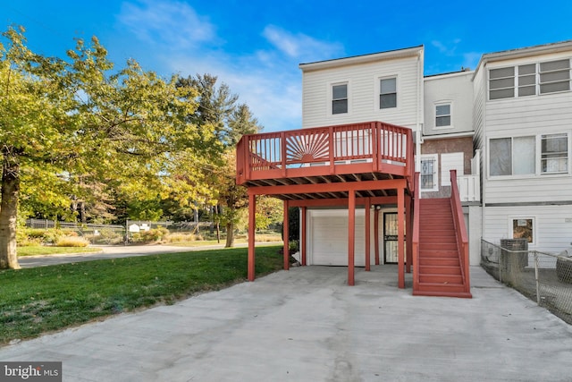 back of house with a wooden deck, a lawn, and a garage