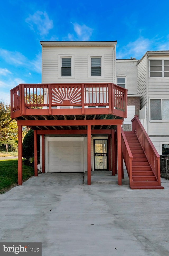 back of property with a deck and a garage