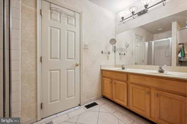 bathroom featuring vanity, tile patterned floors, and a shower with door