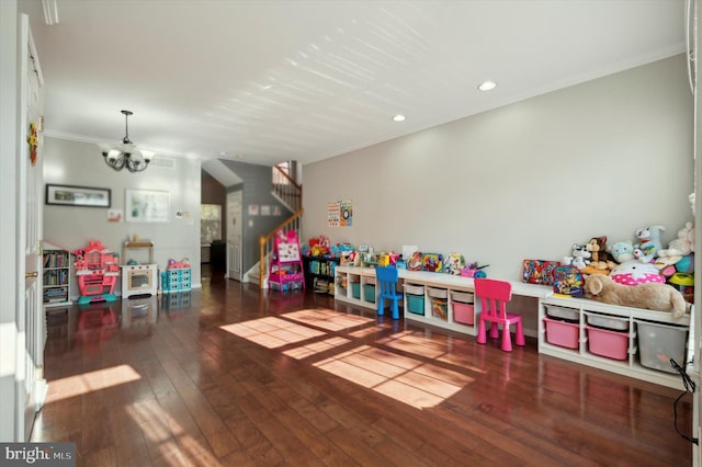 game room with a notable chandelier, crown molding, and dark wood-type flooring