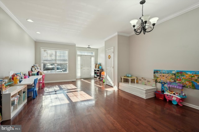 game room with dark hardwood / wood-style floors, an inviting chandelier, and crown molding