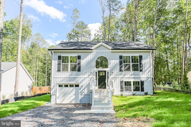 split foyer home with a garage and a front lawn