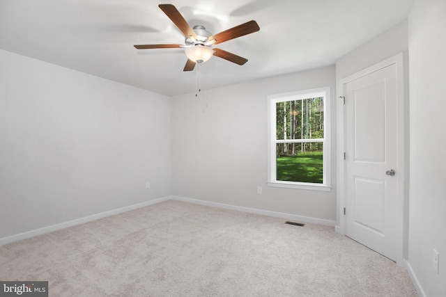 spare room featuring ceiling fan and light carpet