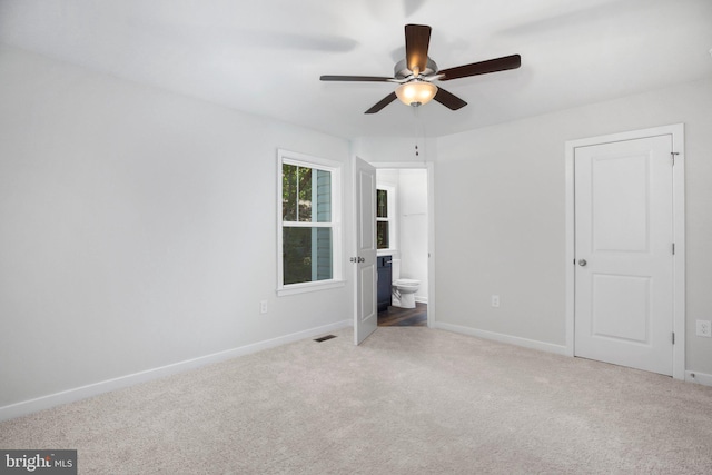 unfurnished bedroom featuring connected bathroom, ceiling fan, and carpet