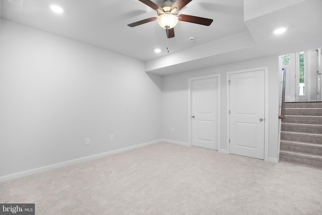 basement with light carpet and ceiling fan