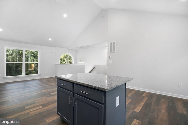 kitchen featuring pendant lighting, a center island, high vaulted ceiling, dark hardwood / wood-style floors, and light stone countertops