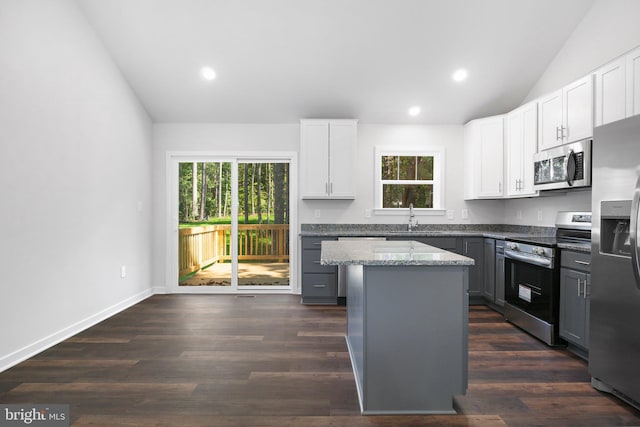 kitchen featuring a center island, sink, stainless steel appliances, vaulted ceiling, and gray cabinets