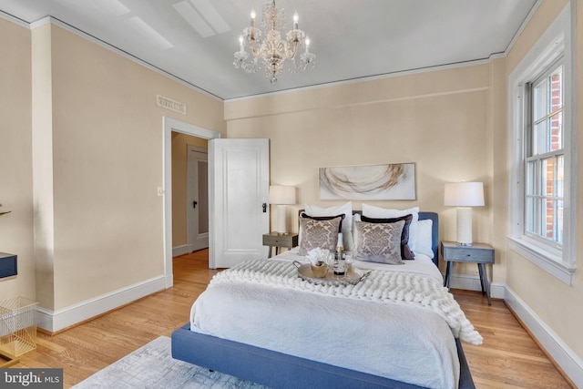 bedroom with crown molding, hardwood / wood-style flooring, and an inviting chandelier