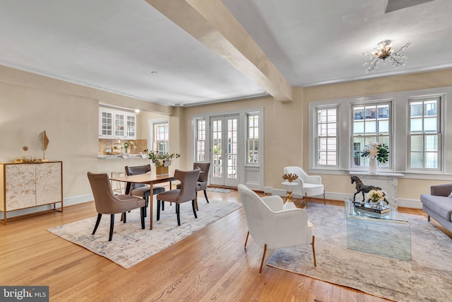 dining room featuring light hardwood / wood-style floors, a notable chandelier, and beamed ceiling