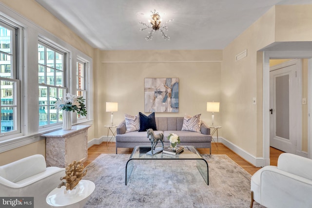 living room with an inviting chandelier and light hardwood / wood-style floors