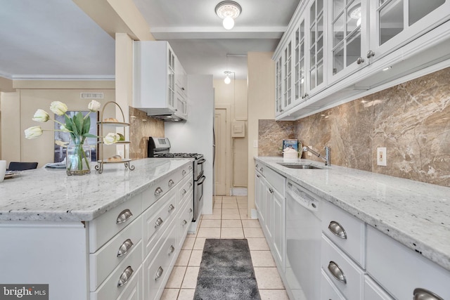 kitchen with sink, stainless steel gas range oven, white dishwasher, white cabinets, and light stone counters