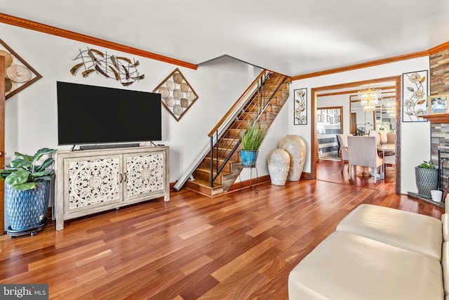 living room featuring ornamental molding, hardwood / wood-style flooring, and an inviting chandelier