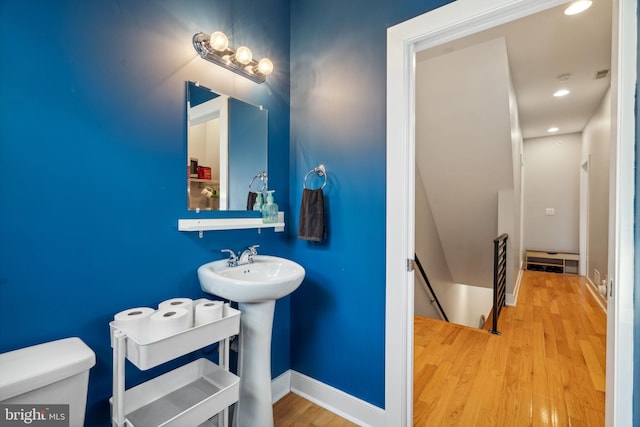 bathroom with toilet, hardwood / wood-style flooring, and sink