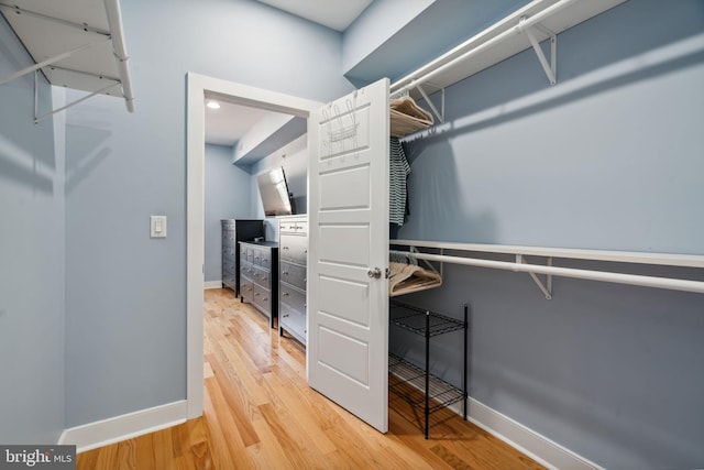 walk in closet with hardwood / wood-style flooring