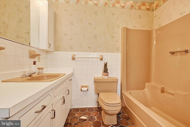 full bathroom featuring vanity, shower / washtub combination, tile walls, and toilet