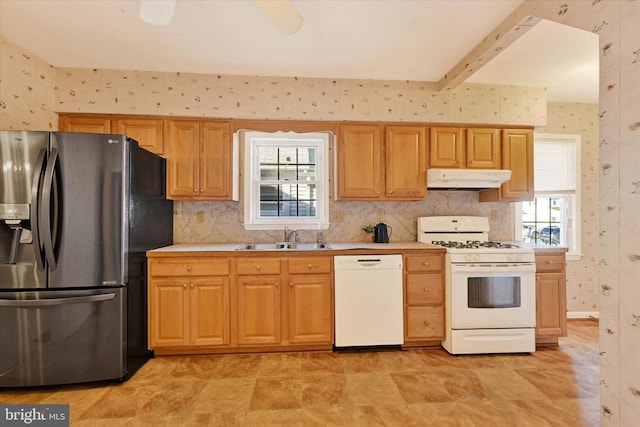 kitchen featuring beam ceiling, a healthy amount of sunlight, sink, and white appliances