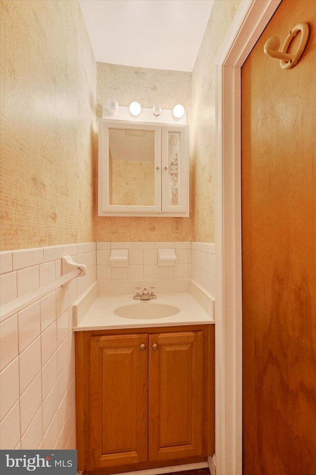 bathroom featuring vanity and tile walls