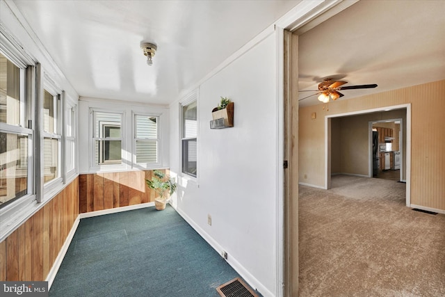 unfurnished sunroom featuring ceiling fan