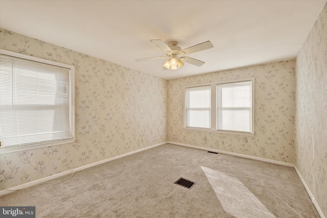 unfurnished room featuring ceiling fan and carpet