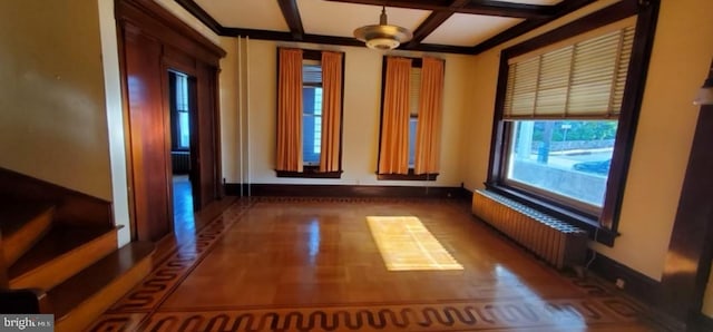 unfurnished room featuring radiator heating unit, beam ceiling, and coffered ceiling