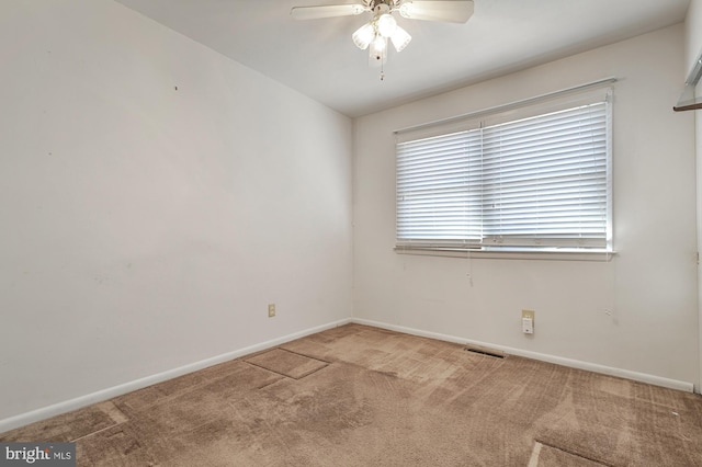 carpeted spare room featuring ceiling fan