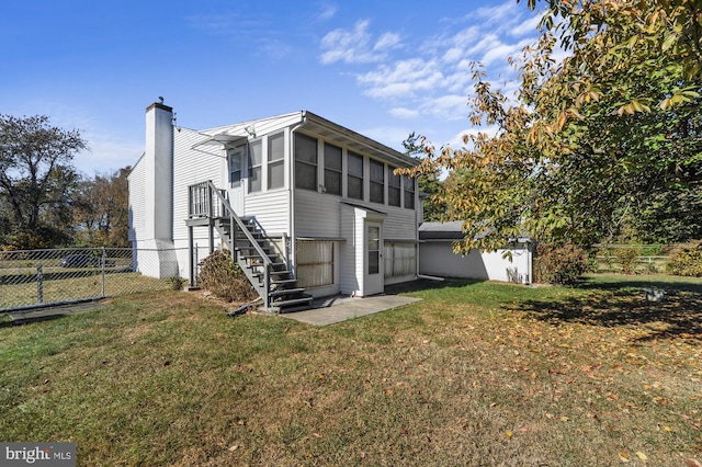 back of house with a lawn and a sunroom